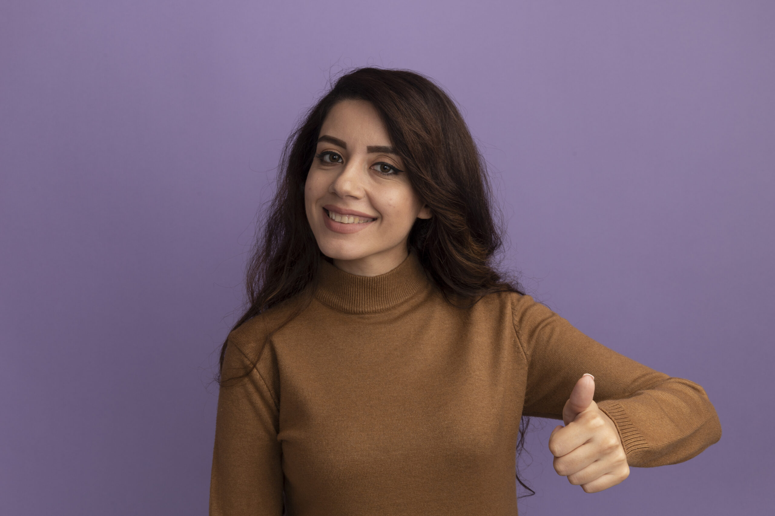 smiling young beautiful girl wearing brown turtleneck sweater showing thumb up isolated on purple background Jessica
